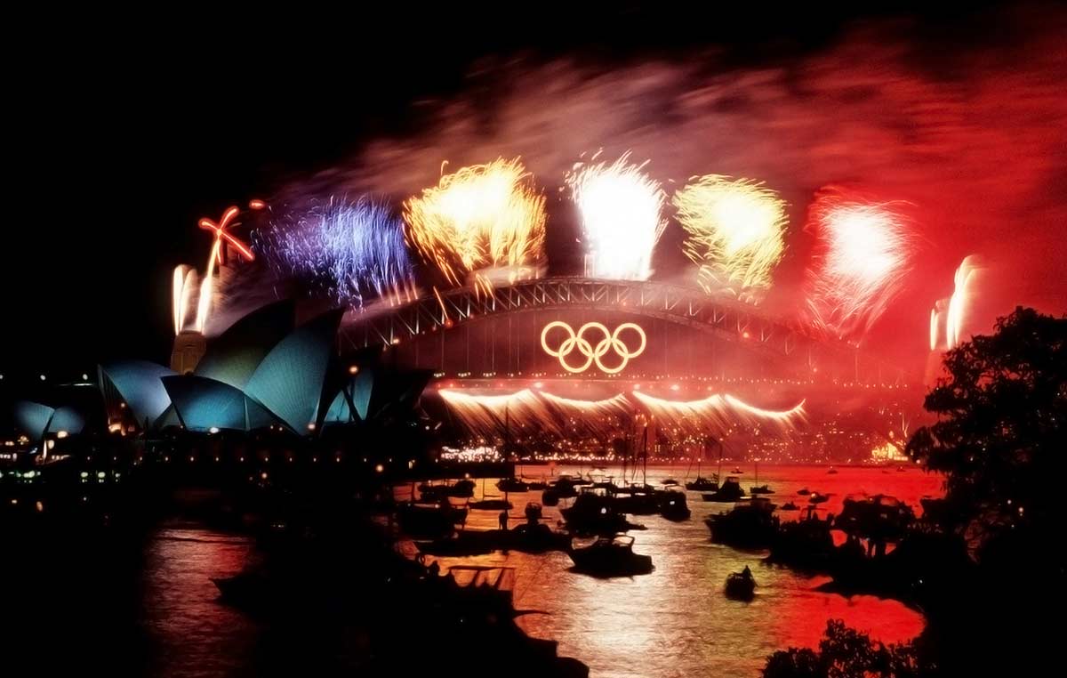 Fireworks over the Sydney Harbour Bridge featuring the Olympics games logo.