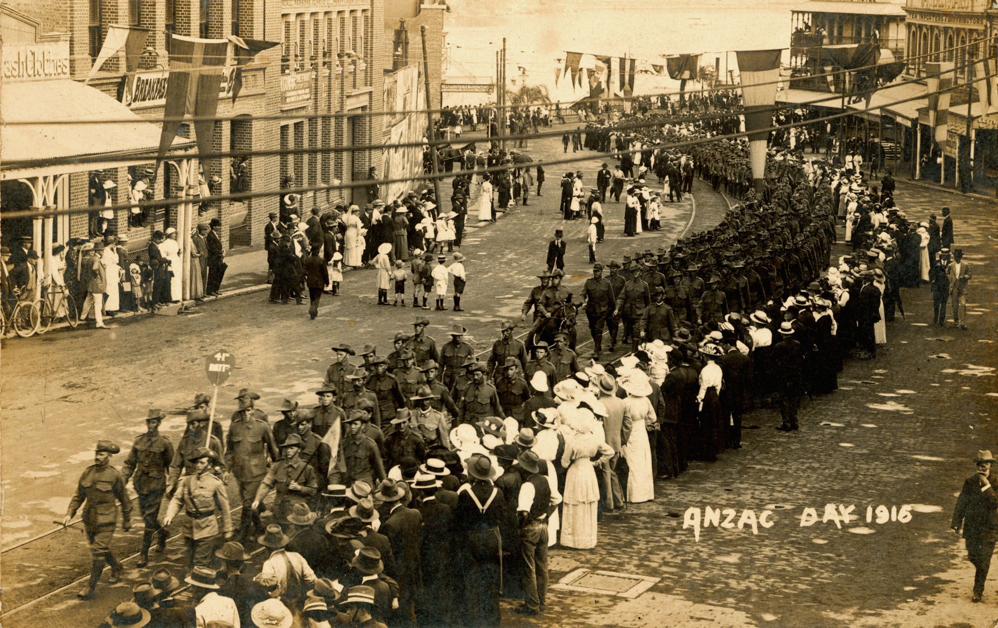 <p>Men, women and children line the streets in Brisbane to watch the procession of the 41st Battalion on Anzac Day, 1916</p>
