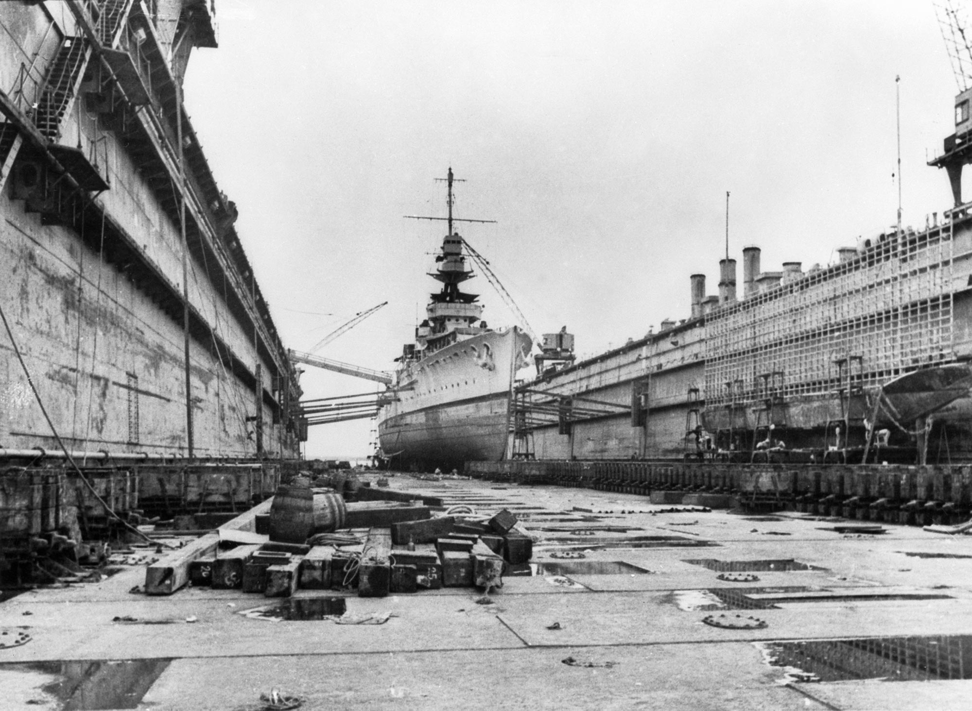 A British warship being refit ted in a floating dock at Singapore naval base, 1940s.