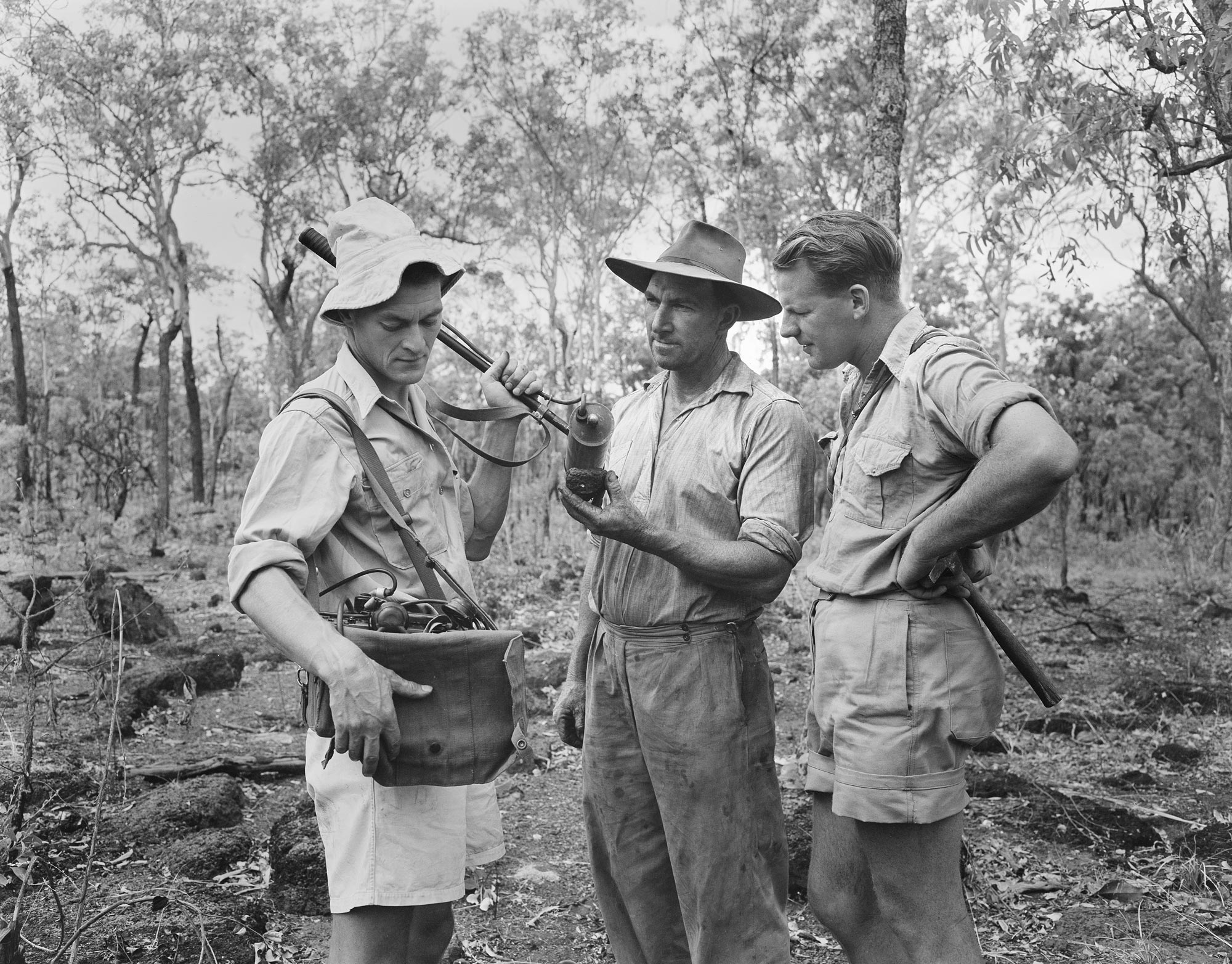 Geologists examining an ore sample with a Geiger counter at Rum Jungle.