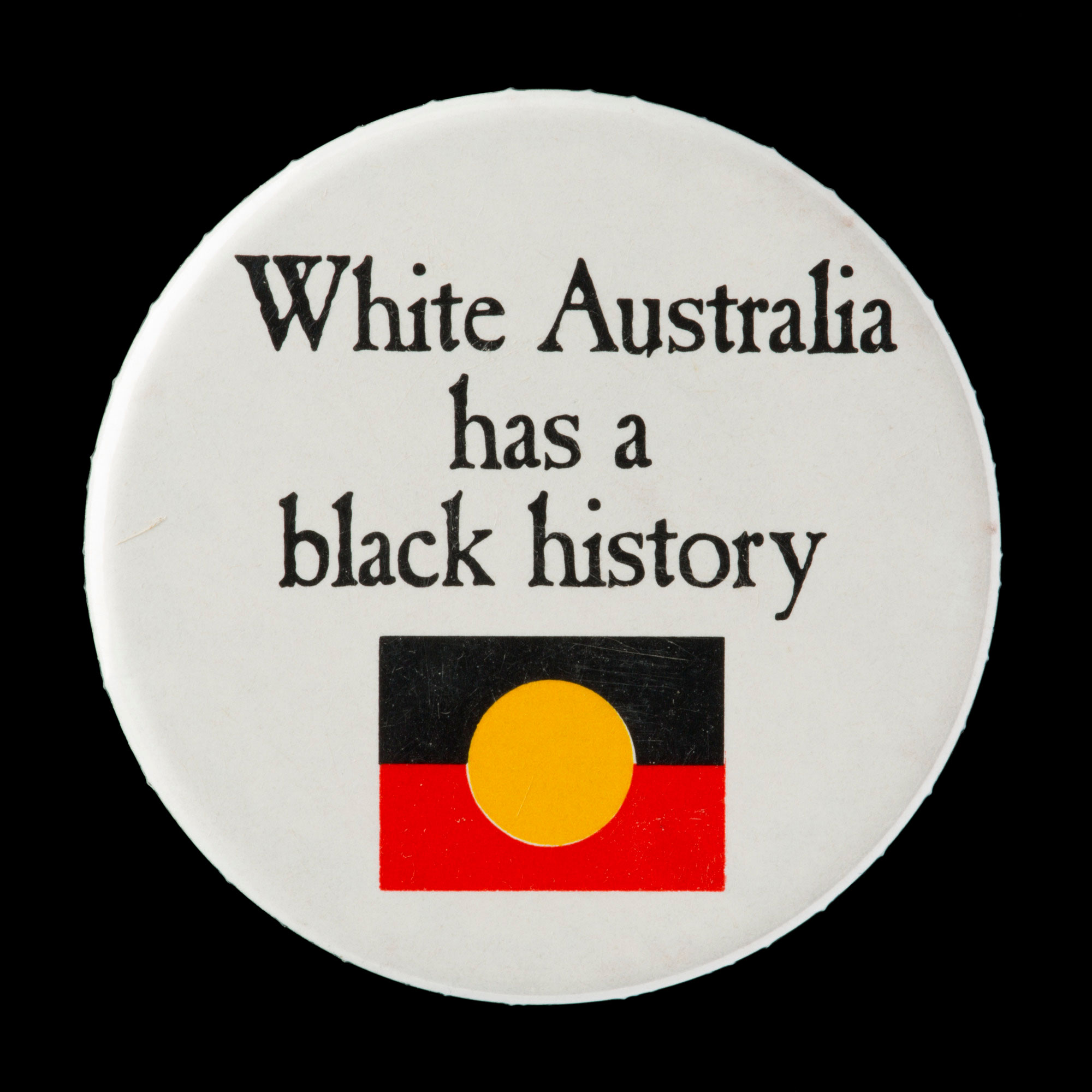 Badge reading ‘White Australia has a black history’.