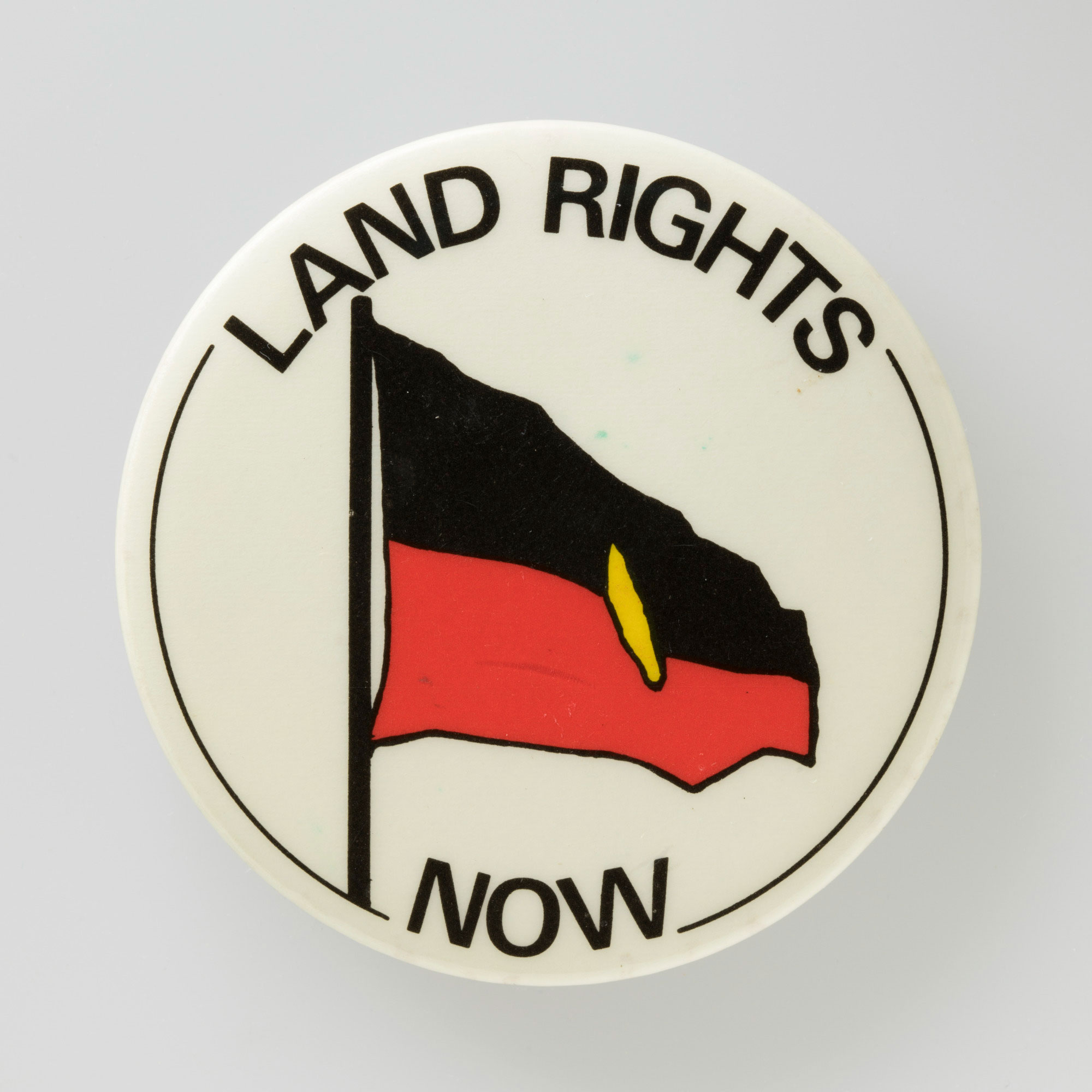 ‘Land Rights Now’ badge.