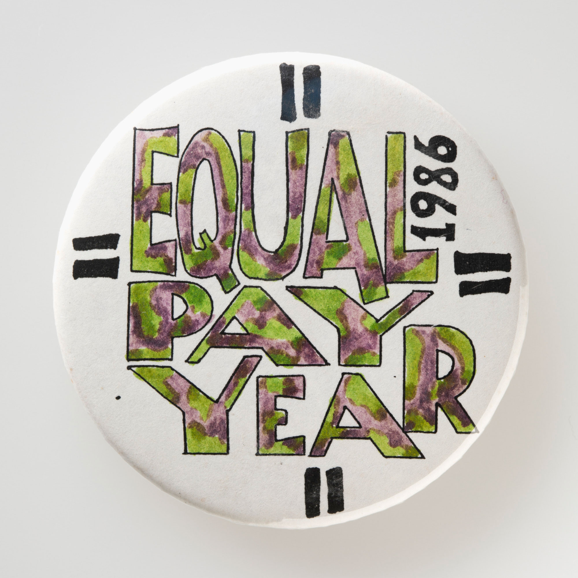 A handmade badge reading ‘Equal Pay Year 1986’.