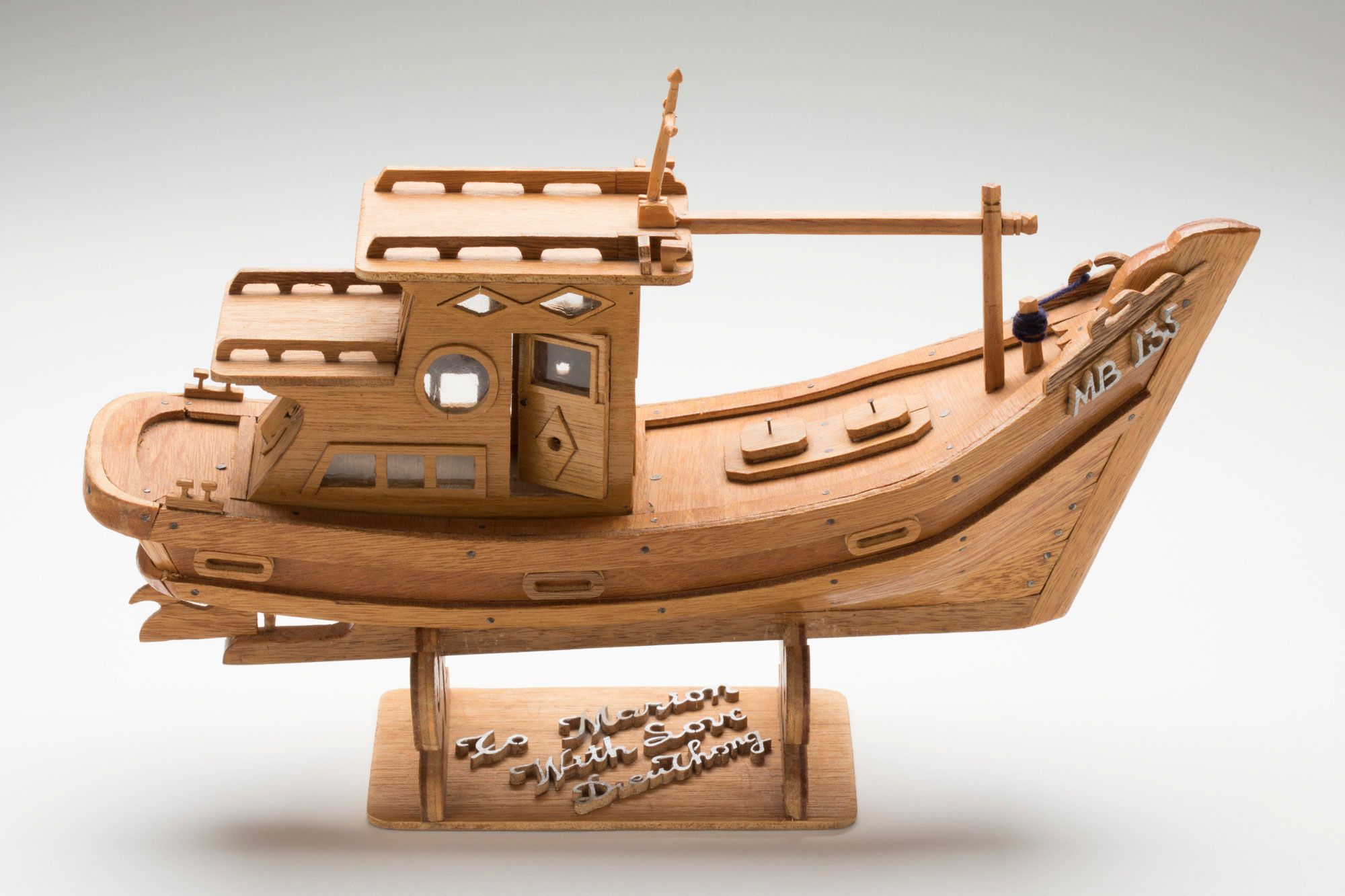 Small wooden replica of Vietnamese refugee boat number MB135.