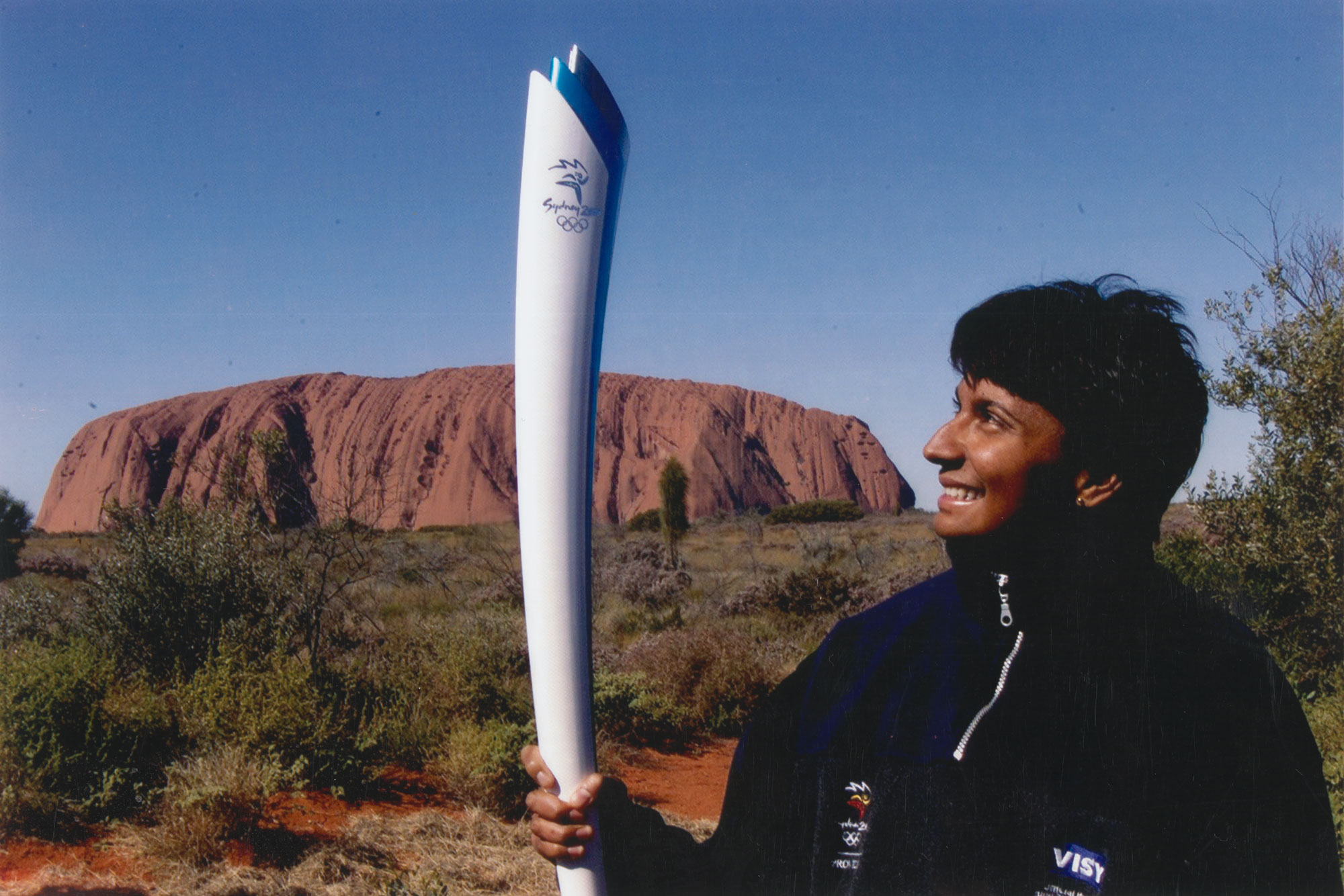 Nova Peris with Sydney 2000 Olympic torch in front of Uluru.