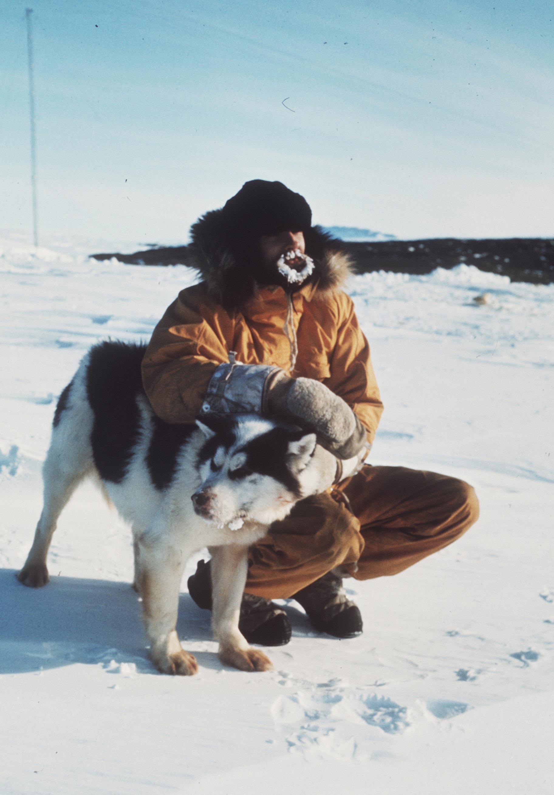 <p>Radio operator Keith Benson with a husky, 1969</p>
