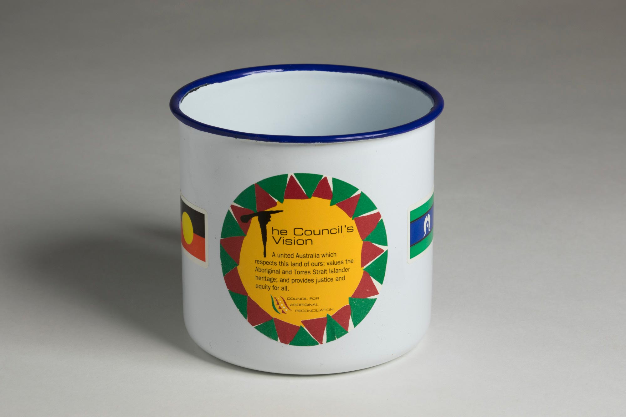 Blue enamel mug bearing a Council for Aboriginal Reconciliation sticker.