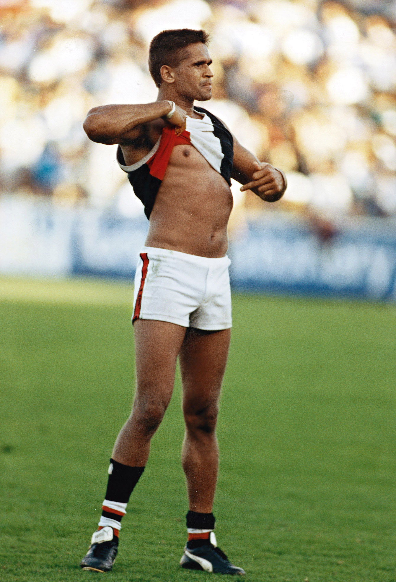St Kilda player Nicky Winmar points to his skin in response to a racist taunt from the crowd.