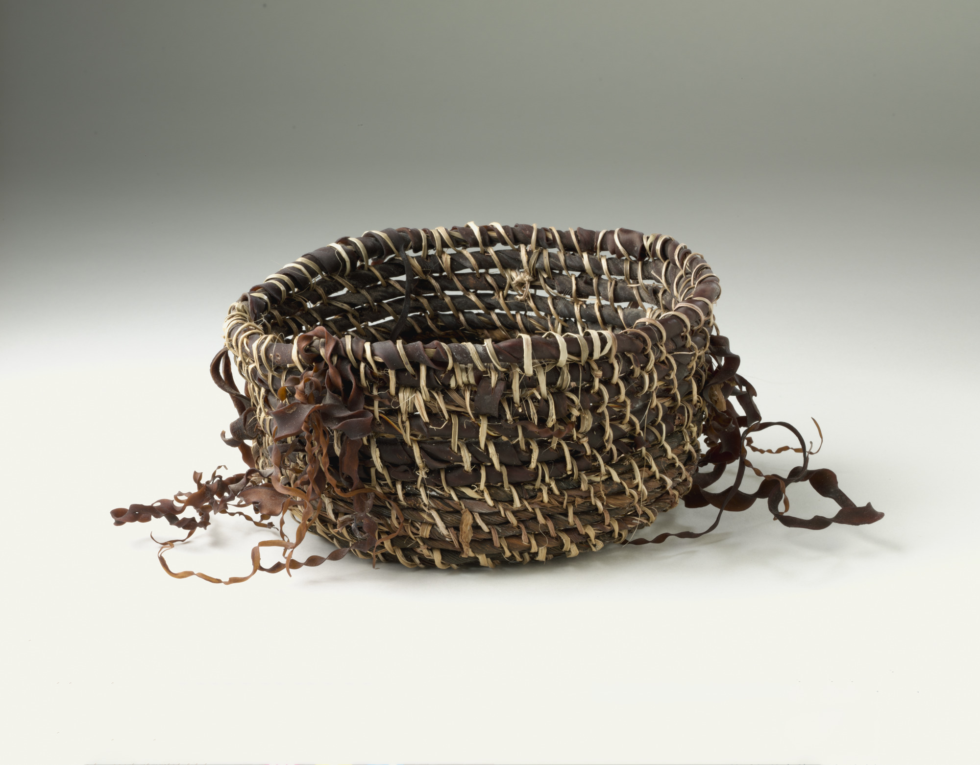 A basket woven from flax and bull kelp, made by Muriel Maynard