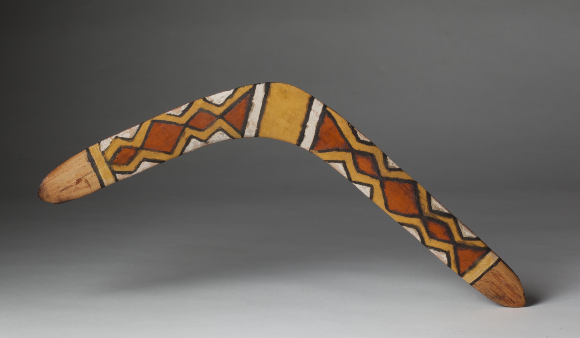 Pigmented, wooden boomerang.