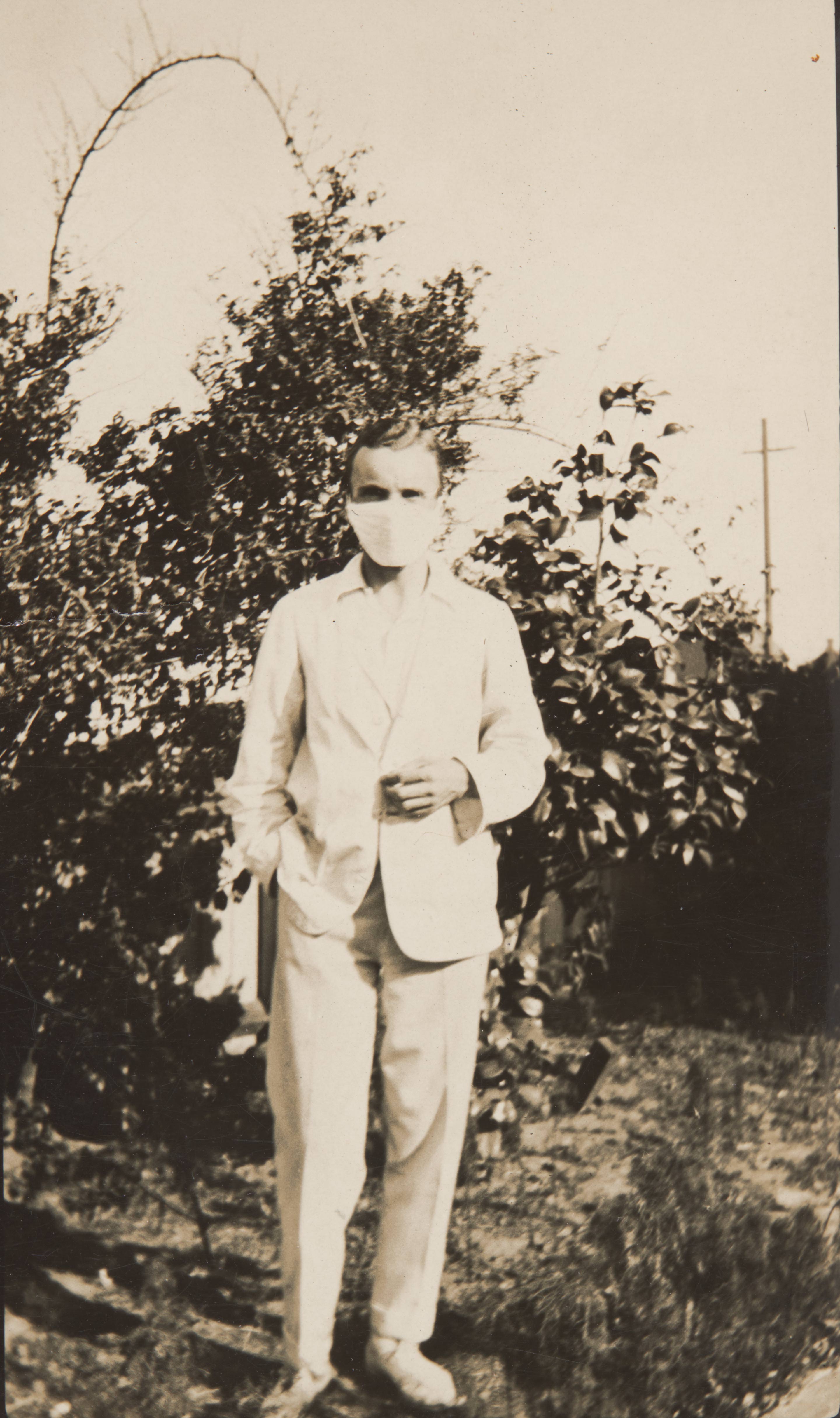Man wearing a white suit and face mask during Spanish flu pandemic, 1918