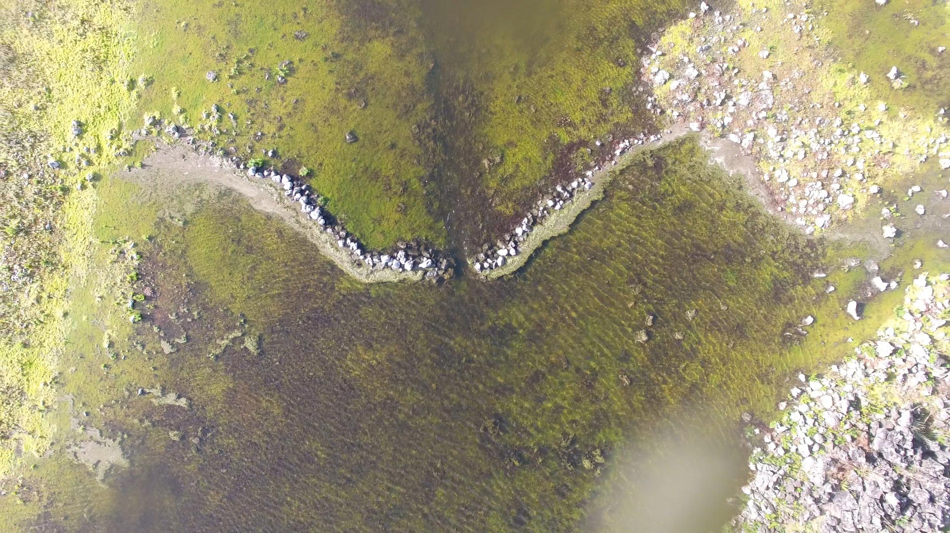 A: An aerial photograph of a line of volcanic rocks, a stream and part of the lake