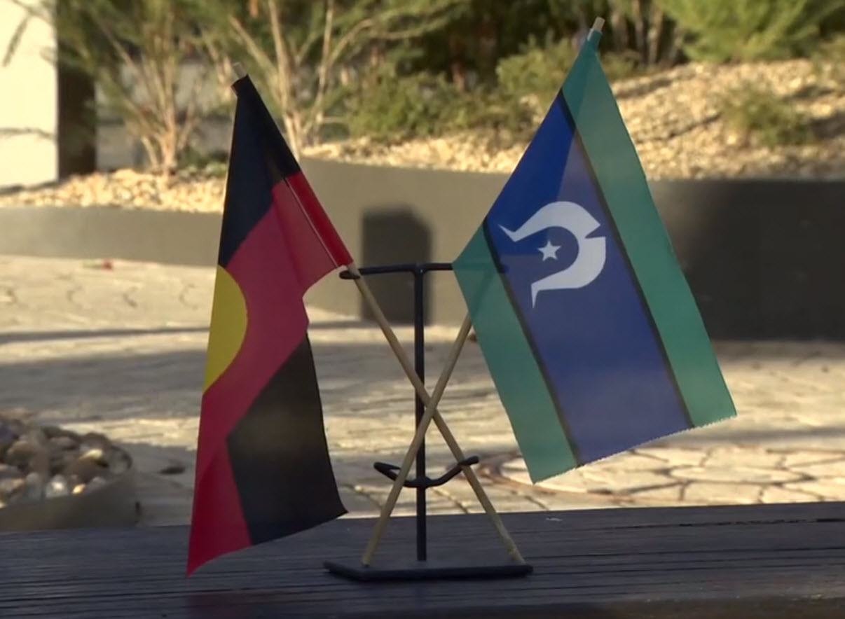 The Aboriginal and Torres Strait Islander flags sitting together on a garden bench