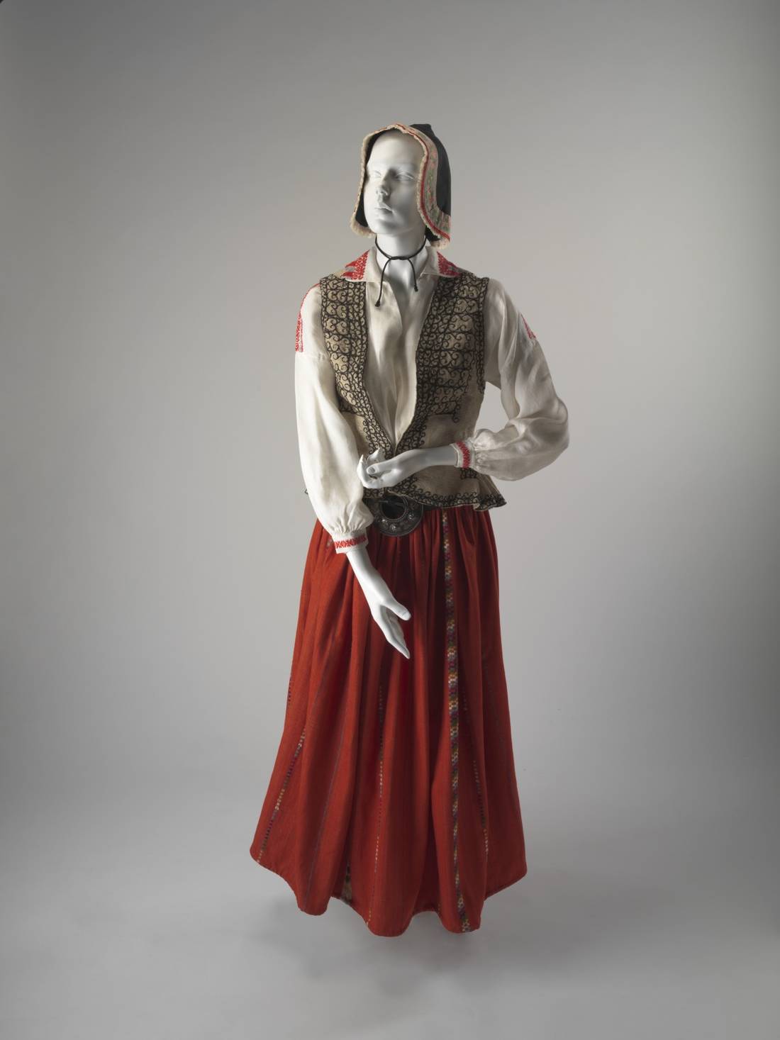 A Latvian woman’s national costume including blouse, waistcoat, skirt, headdress, bonnet and brooches.