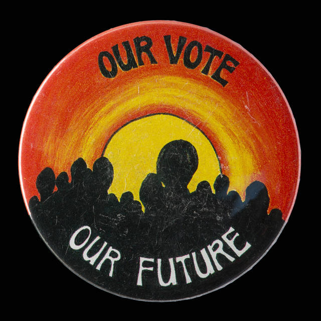 A circular plastic coated metal badge.