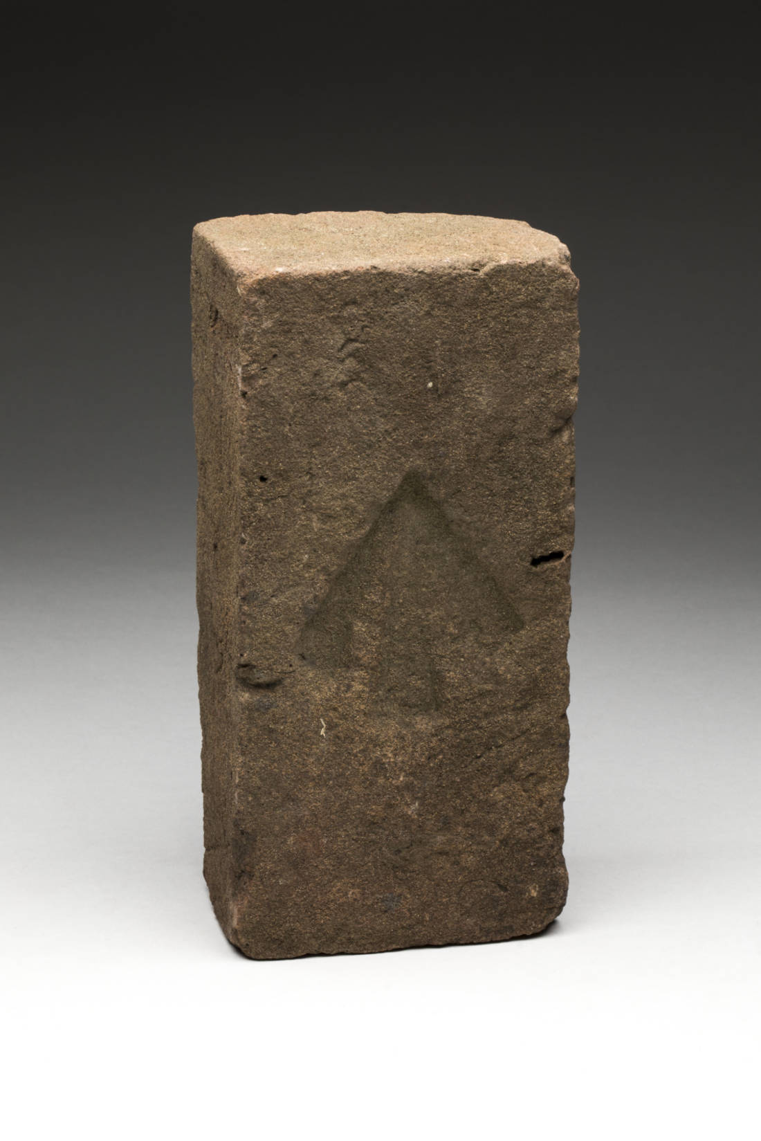 Convict-made brick with an arrow stamped in the centre of one face.