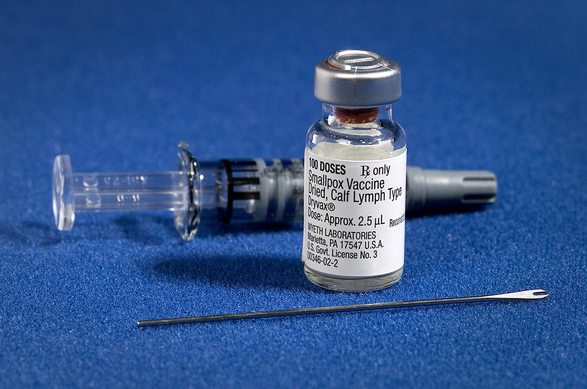 Components of a smallpox vaccination kit including a vial of vaccine and a needle.