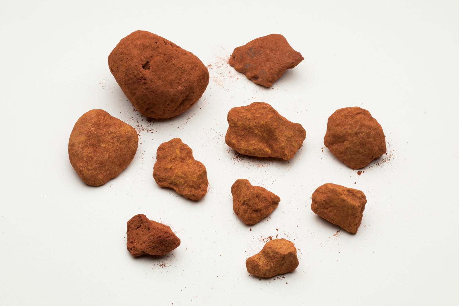 Pieces of red powdery rock on a white background.