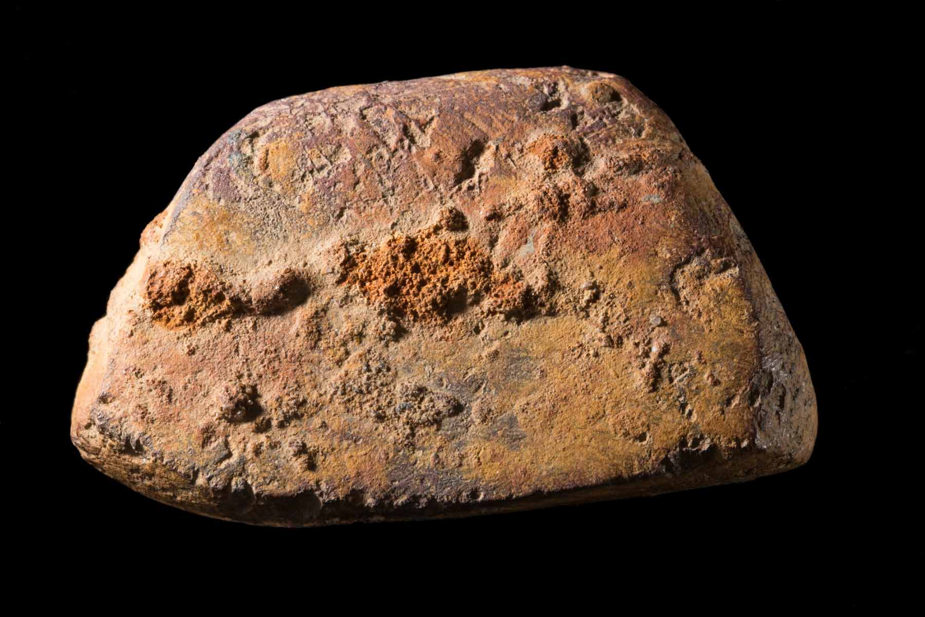 Photograph of a piece of ochre on a black background.