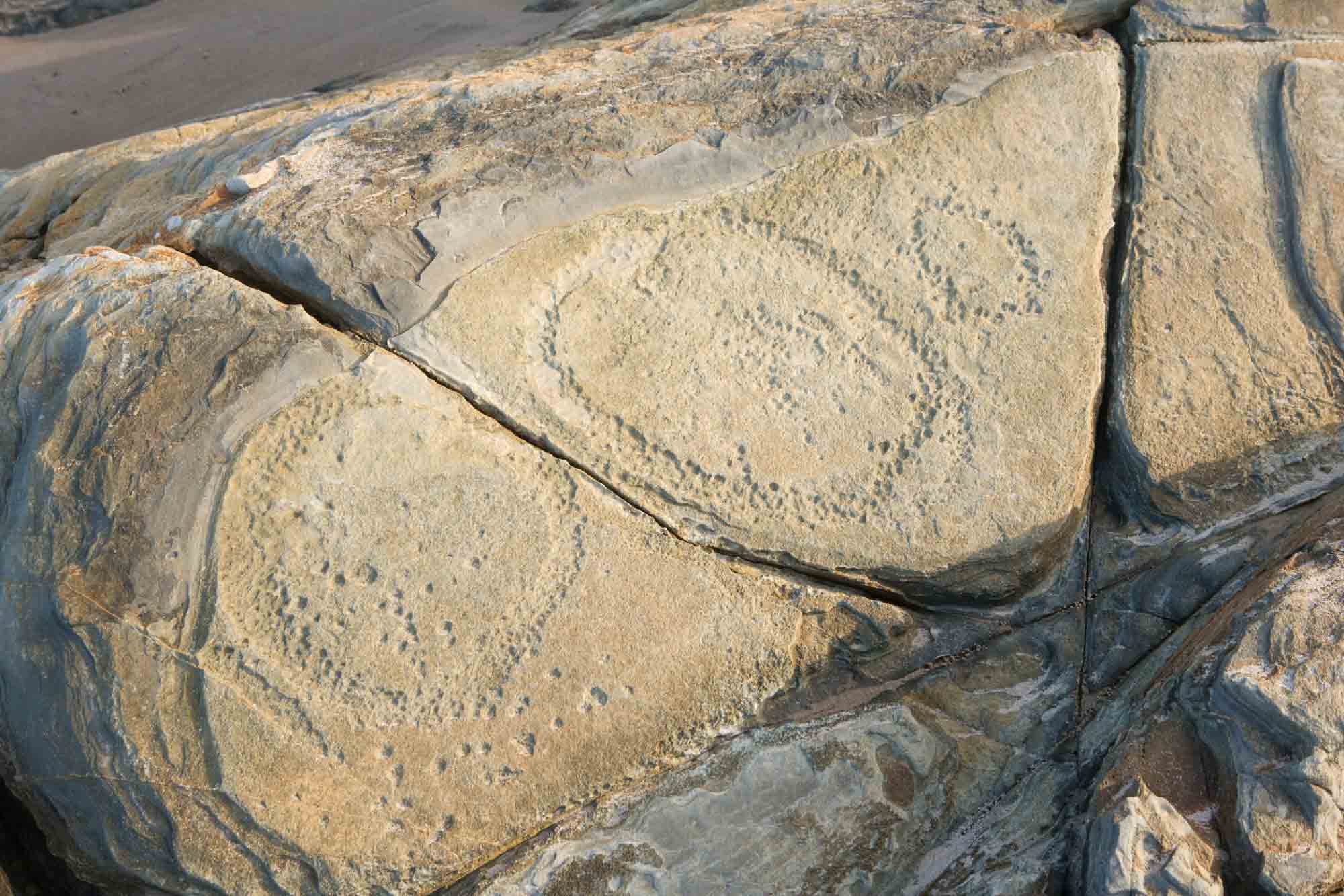 Rock formations featuring circular patterns of dot impressions.