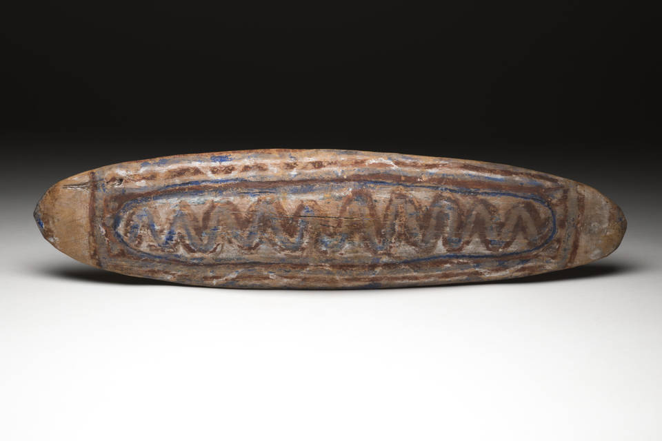 Elliptical wooden shield, with a handle carved out of solid form, flush with the surface. The shield is pigmented with a design in red, cream and blue ochre.