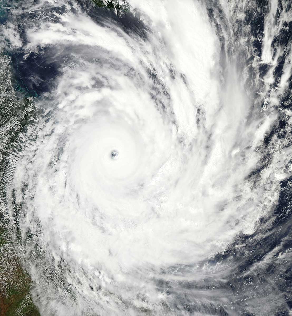 Colour photo of a cyclone above land.