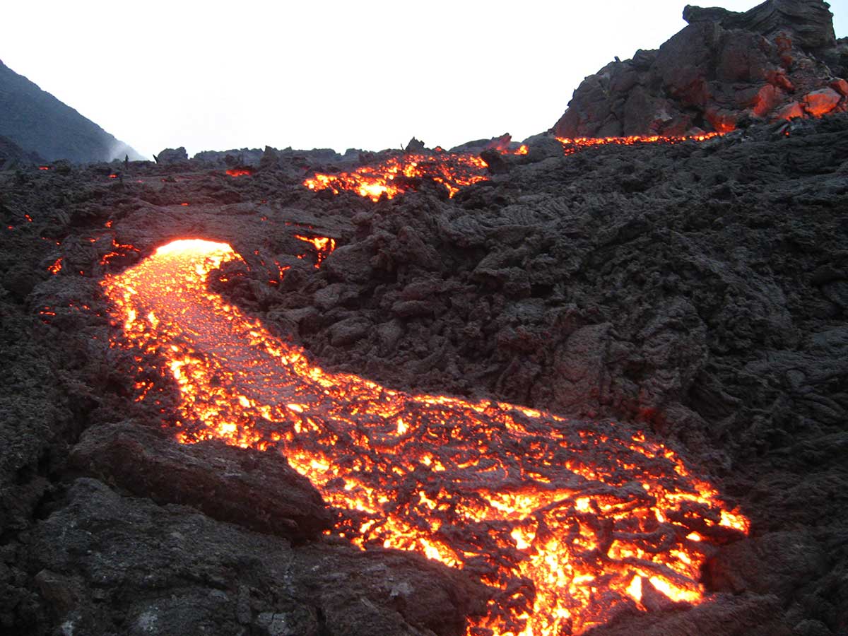 An active volcano showing lava flowing.