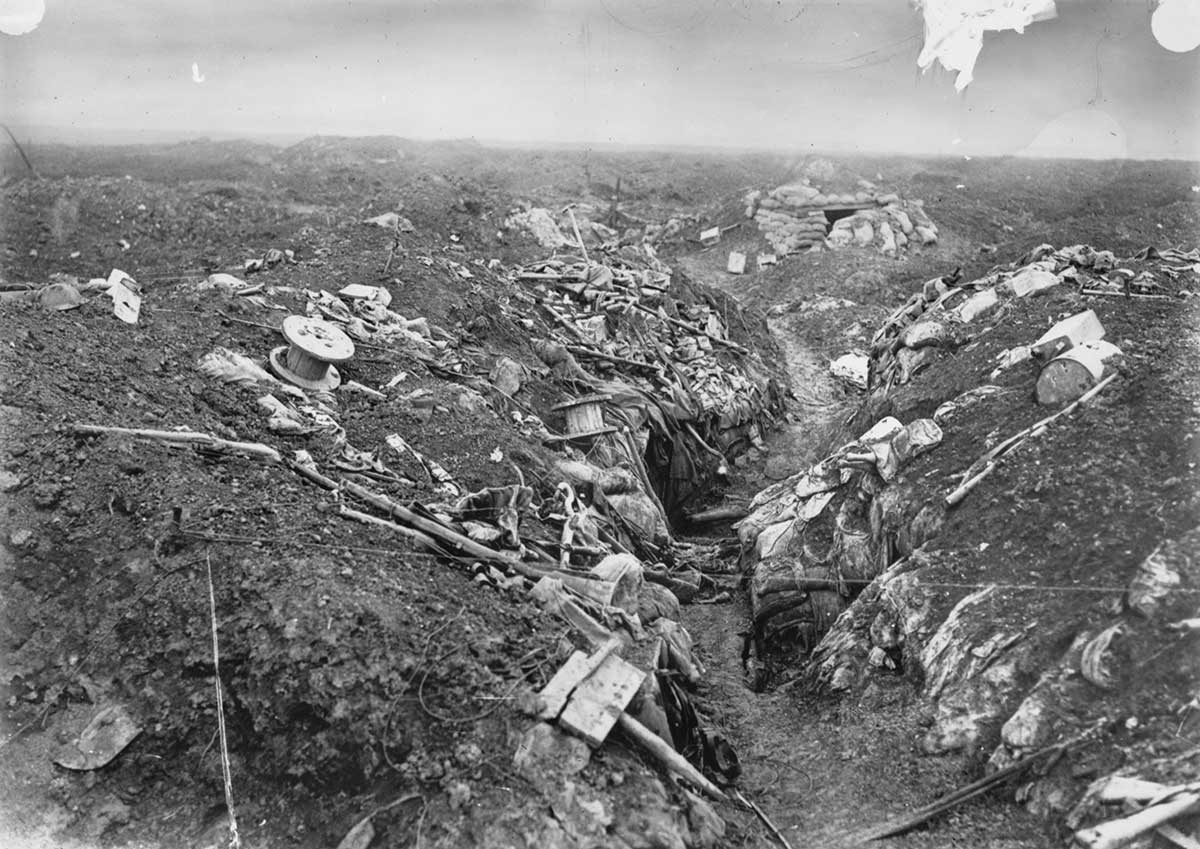  Black and white photograph of a desolate landscape with trenches that have been heavily bombarded.