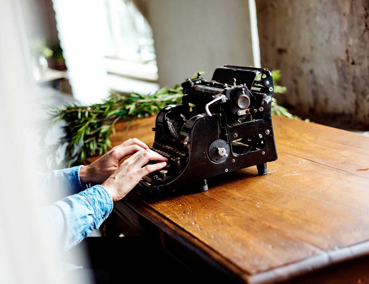 <p>Person using a typewriter</p>
