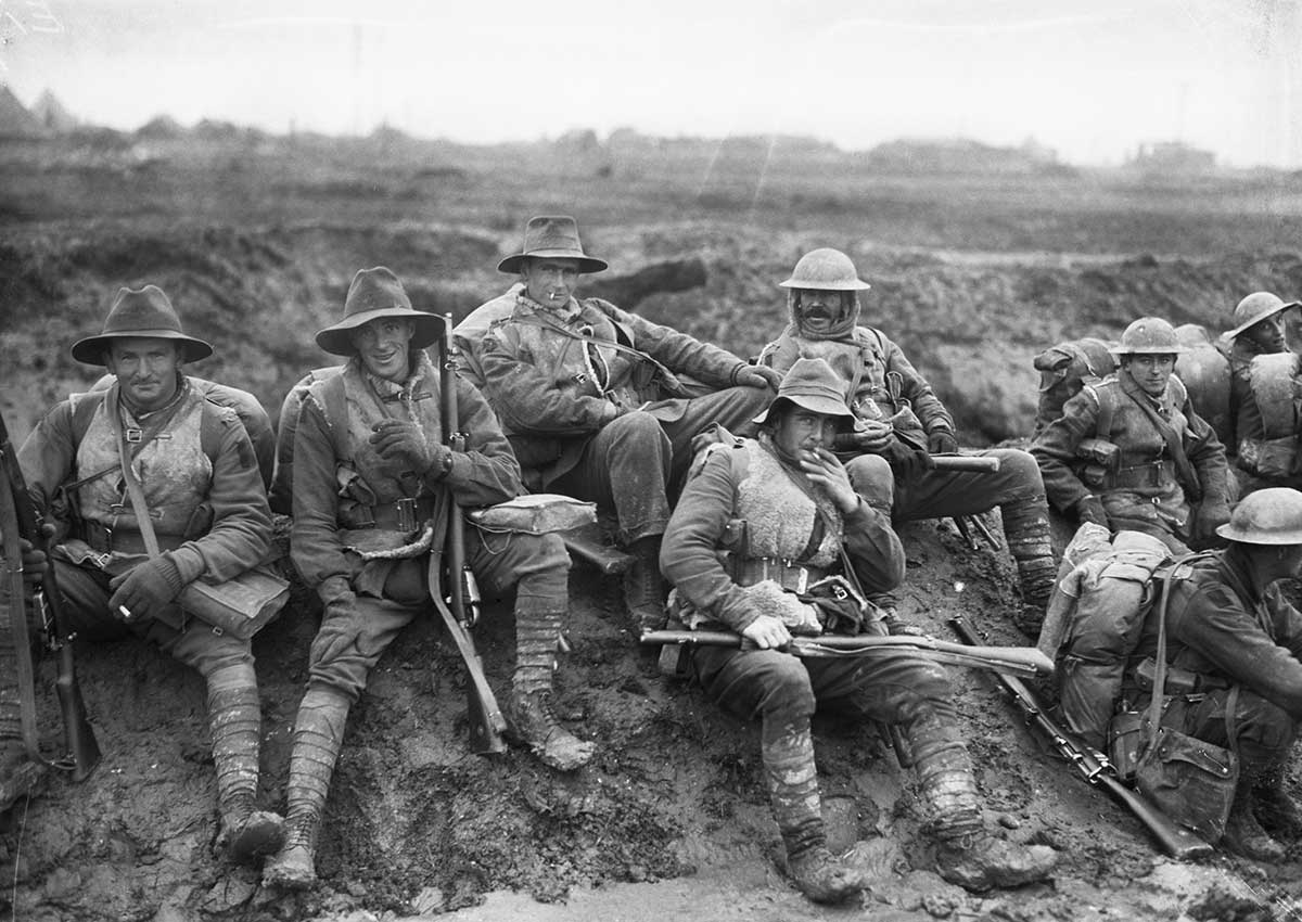 <p>Unidentified men of the 5th Division resting by the side of the Montauban road, near Mametz, while enroute to the trenches, December 1916</p>
