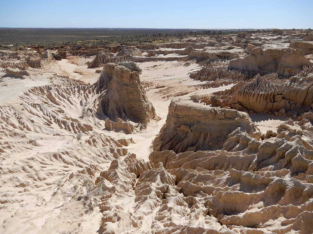 Colour photograph of a dried up salt lake bed featuring formations of silt and sand weathered over hundred of thousands of years.