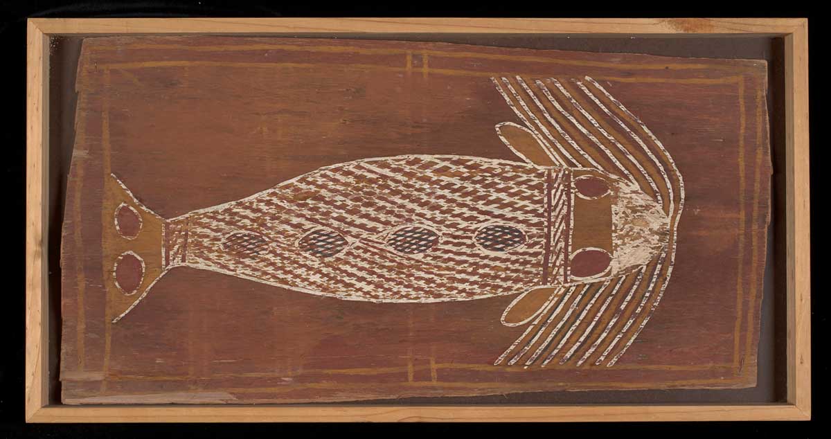 Ochres on bark, in wooden box frame. Depicts a whale with a crosshatched body, two circles on the head and two on the tail (red), four more along the body (crosshatched). Curving across the whale's nose are yellow and white parallel lines. Red background, yellow lines framing the whale.