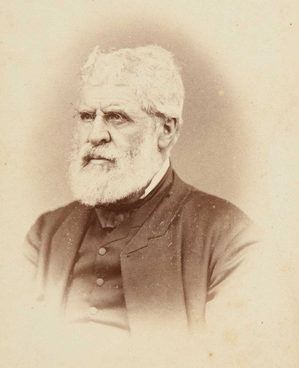 Black and white photograph portrait of a man with beard and spectacles.