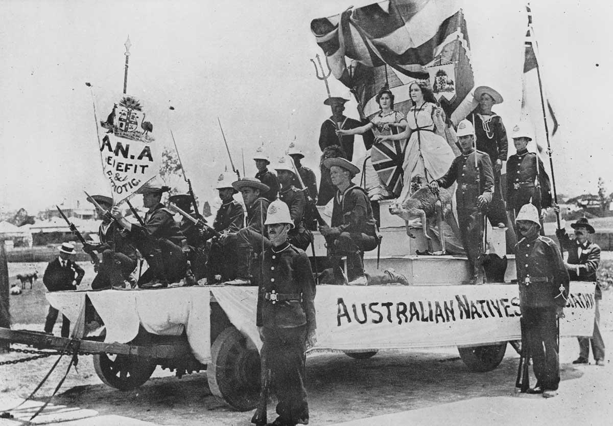 Black and white photograph of the Australian Natives’ Association float carrying soldiers and two women in costume, one holding a trident and the other a banner.